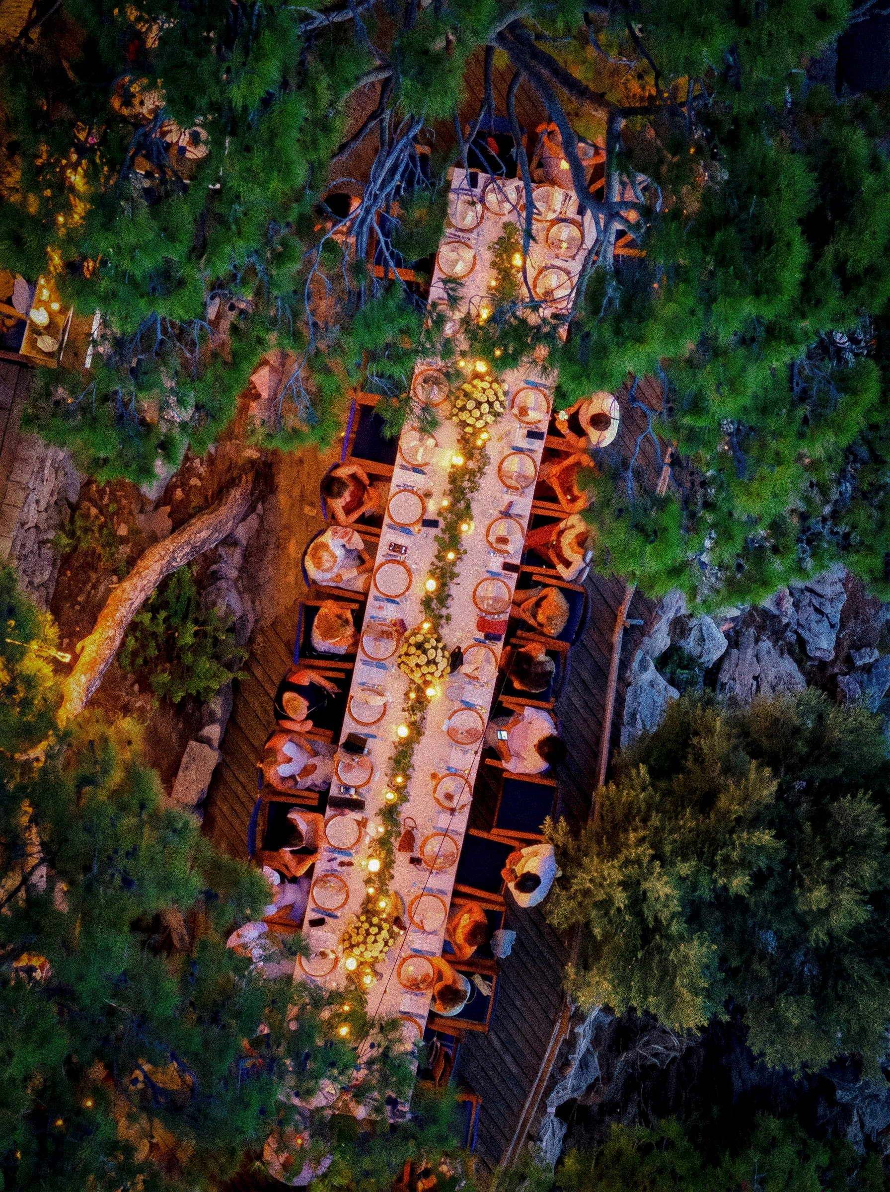 Guests gathered around candlelit tables at night