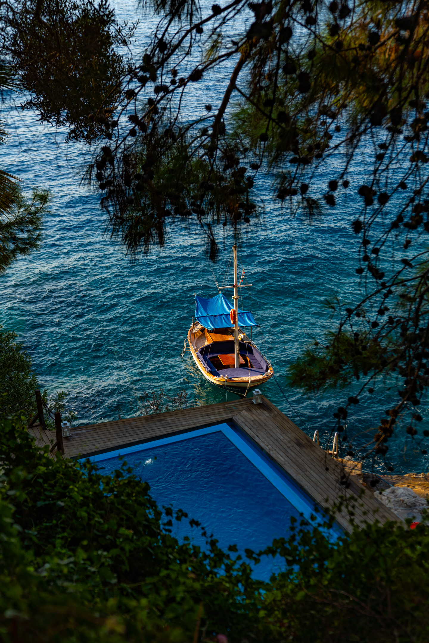 A traditional wooden piyade boat beside a rocky shore